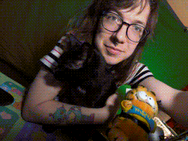 Image of me, my cat Corez, a Garfiled plush, sitting at my desk in front of a green screen